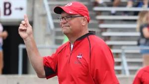A Football Coach Strategizing On Field Wallpaper