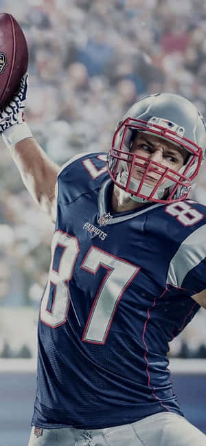 A Football Player Is Holding A Football Wallpaper