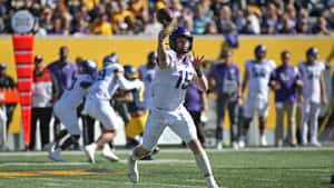 A Football Player Throwing A Ball In A Game Wallpaper