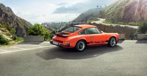 A Glittering Tangerine Porsche 911 In Natural Light Wallpaper