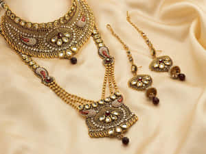 A Gold And Red Jewelry Set With A Necklace And Earrings Wallpaper