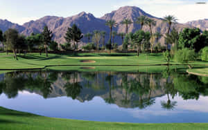 A Golf Course With Mountains In The Background Wallpaper