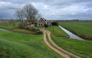 A Green Field With A House Wallpaper