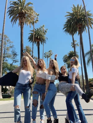 A Group Of Girls In Jeans And T-shirts Posing For A Photo Wallpaper