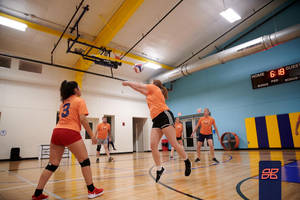 A Group Of Girls Playing Volleyball In A Gym Wallpaper