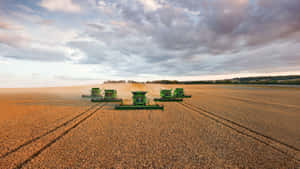 A Group Of Green Machines In A Field Wallpaper