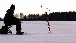 A Group Of Ice Anglers Enjoying A Day Of Ice Fishing On A Frozen Lake Wallpaper