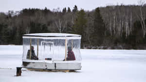 A Group Of Ice Anglers Enjoying A Day On The Frozen Lake Wallpaper