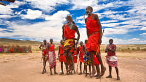 A Group Of People In Red Clothing Are Standing In A Field Wallpaper