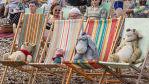 A Group Of People Sitting On Beach Chairs Wallpaper