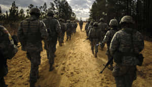 A Group Of Soldiers Walking Down A Dirt Road Wallpaper