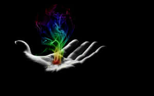 A Hand With A Rainbow Colored Flame In It Wallpaper