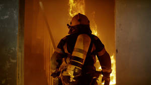 A Hero's Ascent - Firefighter Climbing The Stairs In Action. Wallpaper