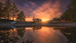 A House Is Reflected In The Water At Sunset Wallpaper