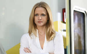 A.j. Cook Striking A Pose In A Black Outfit Against A Blue Background Wallpaper