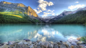 A Lake Surrounded By Mountains And Rocks Wallpaper