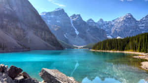 A Lake Surrounded By Mountains And Rocks Wallpaper