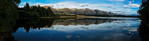 A Lake Surrounded By Mountains And Trees Wallpaper