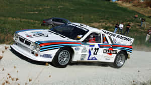 A Lancia Delta Integrale In Motion On A Scenic Road Wallpaper