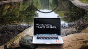 A Laptop Is Sitting On A Log Wallpaper