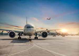 A Large Airplane Is On The Tarmac At An Airport Wallpaper