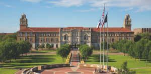 A Large Building With A Flag Flying In Front Of It Wallpaper