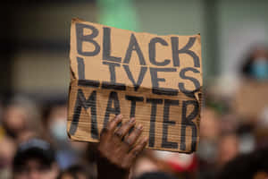 A Large Crowd Protesting Against Systemic Racism And Inequality Wallpaper