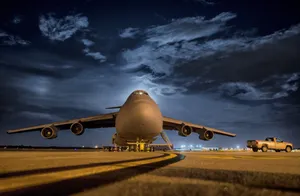 A Large Military Aircraft On The Runway At Night Wallpaper