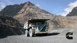 A Large Truck Driving Through A Mine Wallpaper