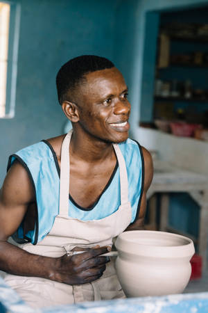 A Local Artisan Shaping Pottery In Sierra Leone Wallpaper