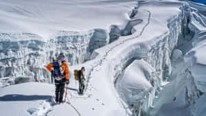 A Lone Skier Carving A Path Through Pristine Mountain Snow. Wallpaper