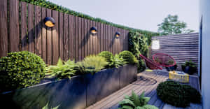 A Lush And Beautiful Garden With A Variety Of Plants And Flowers Surrounding A Tranquil Pond. Wallpaper