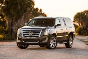 A Luxurious Cadillac Escalade Cruising Down The Street Wallpaper