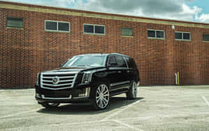 A Luxury Cadillac Escalade On The Road Wallpaper