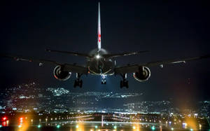 A Majestic Airplane Flying Into The Night Wallpaper