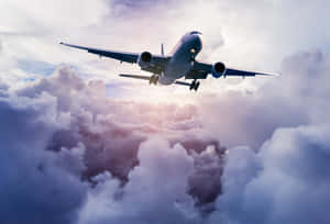 A Majestic Passenger Airplane Soars Through The Clouds Wallpaper