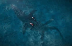 A Man And Woman Are Swimming In The Ocean With A Whale Wallpaper