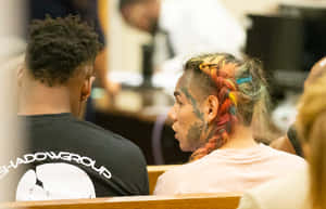 A Man And Woman Sitting In A Courtroom Wallpaper