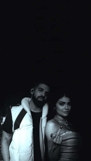 A Man And Woman Standing Next To Each Other Wallpaper