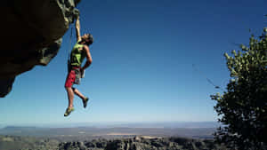 A Man Experiencing An Ultimate Thrill As He Skydives Over A Vast, Breathtaking Landscape. Wallpaper