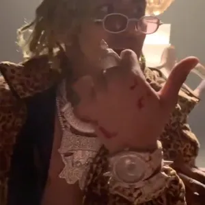 A Man In A Leopard Jacket Is Holding A Gun Wallpaper