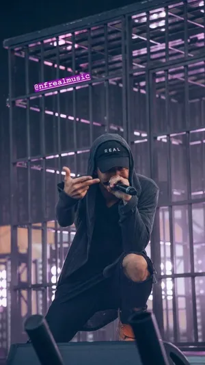 A Man In A Purple Shirt Is Standing On Stage Wallpaper