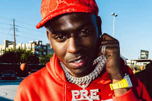 A Man In A Red Hoodie Is Holding A Cell Phone Wallpaper