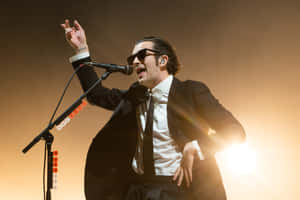 A Man In A Suit And Tie Singing Into A Microphone Wallpaper