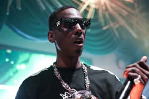 A Man In Sunglasses Is Holding A Microphone Wallpaper