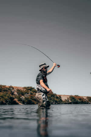 A Man Is Fly Fishing In The Water Wallpaper