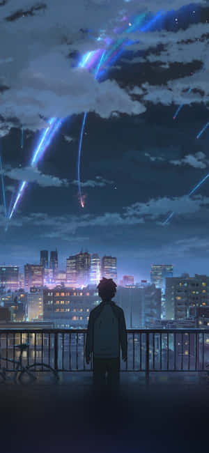 A Man Is Looking Out Over A City At Night Wallpaper