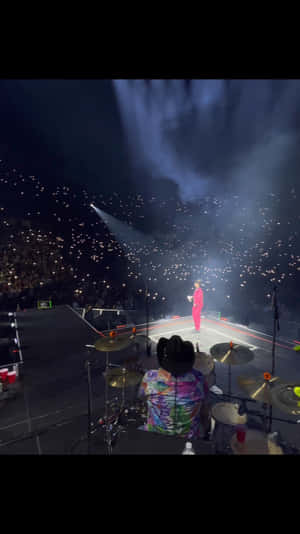 A Man Is Playing Drums In A Concert Wallpaper