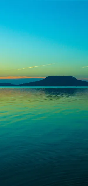 A Man Is Riding A Boat On A Lake At Sunset Wallpaper