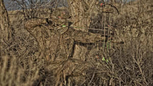 A Man Is Standing In The Grass With A Bow Wallpaper